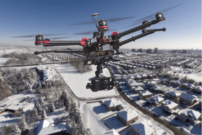 drönare med kamera flyger över snötäckt villaområde