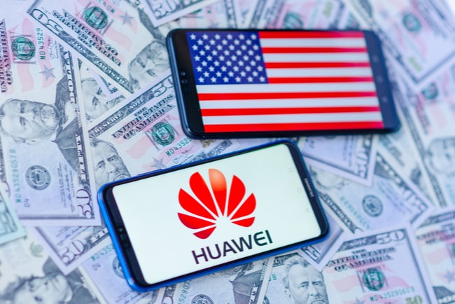 två telefonskärmar med huaweis logotyp och USA:s flagga på bakgrund av amerikanska dollar