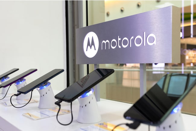 Motorola-mobiler på rad i skyltfönster med motorolas logga bakom.